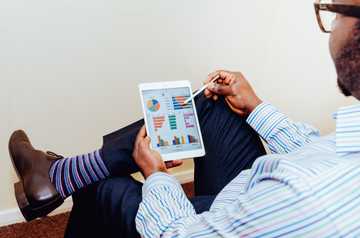 Photo of a man looking at a report on an iPad screen